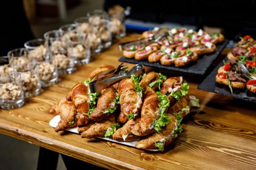 Stacks of croissant sandwich on a wooden table