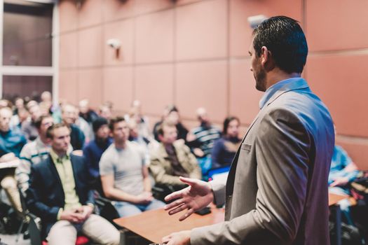 Speaker at Business Conference with Public Presentations. Audience at the conference hall. Business and Entrepreneurship concept. Background blur. Shallow depth of field.