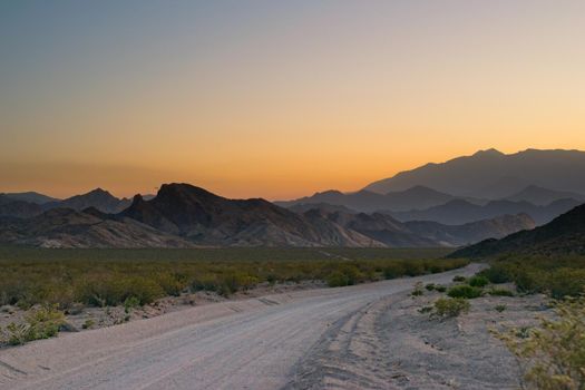 Dirt road across the desert, and into the hazy mountains near Uspallata, Mendoza, Argentina.
