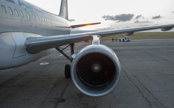 The wing and engine of the plane in the light of the setting sun