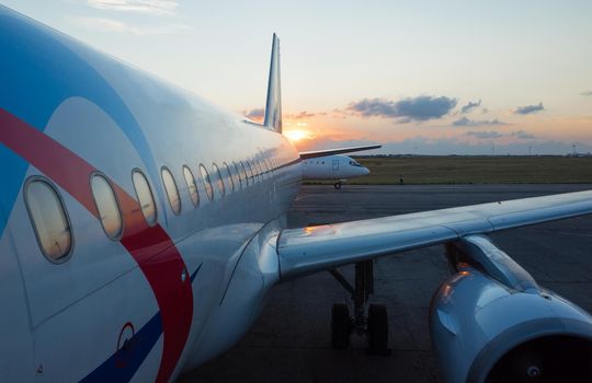 The wing and engine of the plane in the light of the setting sun
