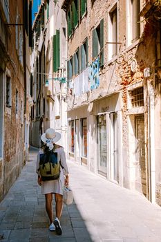Beautiful venetian street in summer day, Italy. Venice Europe woman on city trip in Venice