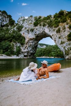 couple on the beach by the river in the Ardeche France Pont d Arc, Ardeche France,view of Narural arch in Vallon Pont D'arc in Ardeche canyon in France Europe