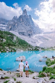 Couple visit the blue green lake in the Italian Dolomites,Beautiful Lake Sorapis Lago di Sorapis in Dolomites, popular travel destination in Italy. Europe