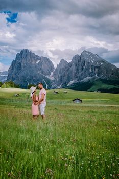couple men and woman on vacation in the Dolomites Italy, Alpe di Siusi - Seiser Alm Dolomites, Trentino Alto Adige, South Tyrol, Italy. Europe