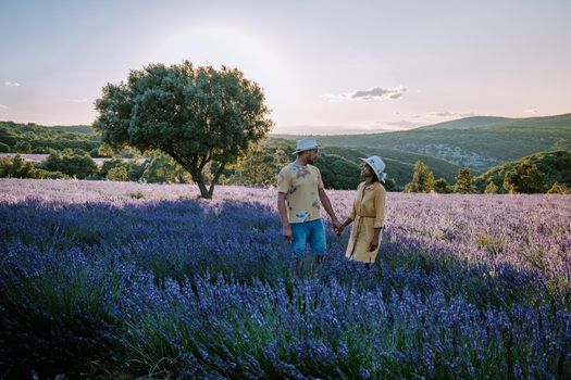 couple men and woman watching sunset in lavender fields in the south of France, Ardeche lavender fields iduring sunset, Lavender fields in Ardeche in southeast France.Europe
