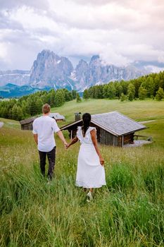 couple men and woman on vacation in the Dolomites Italy, Alpe di Siusi - Seiser Alm Dolomites, Trentino Alto Adige, South Tyrol, Italy. Europe