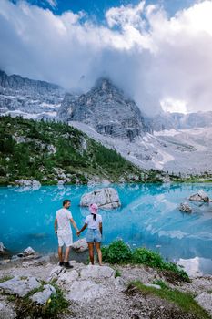 Couple visit the blue green lake in the Italian Dolomites,Beautiful Lake Sorapis Lago di Sorapis in Dolomites, popular travel destination in Italy. Europe