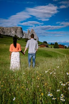 couple men and woman on vacation in the Dolomites Italy, Alpe di Siusi - Seiser Alm Dolomites, Trentino South Tyrol, Italy, Europe. 