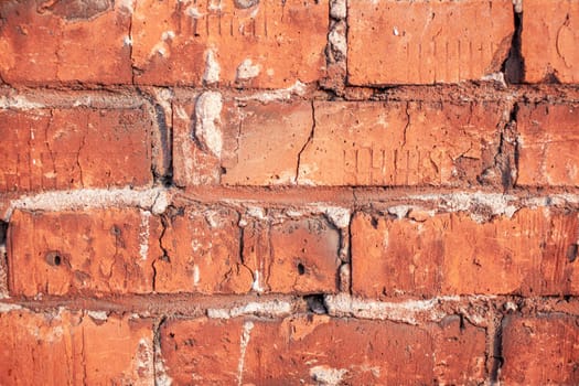 Old red brick wall. The bricks are laid in rows. Grunge stone texture. High quality photo