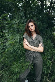 Woman in forest crossed her arms and jumpsuit nature travel cropped view