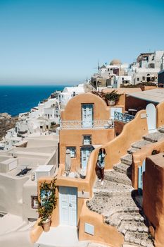 Santorini Greece, young man on luxury vacation at the Island of Santorini watching sunrise by the blue dome church and whitewashed village of Oia Santorini Greece during sunrise during summer vacation, men on holiday in Greece