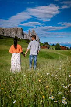 couple men and woman on vacation in the Dolomites Italy, Alpe di Siusi - Seiser Alm Dolomites, Trentino Alto Adige, South Tyrol, Italy. Europe