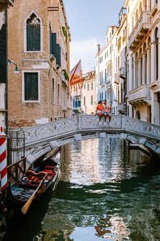 couple men and woman on a city trip to Venice Italy, colorful streets with canals Venice. Europe