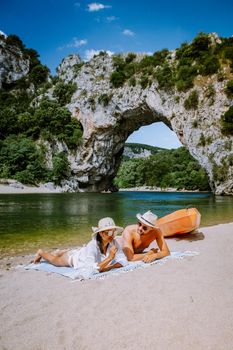 couple on the beach by the river in the Ardeche France Pont d Arc, Ardeche France,view of Narural arch in Vallon Pont D'arc in Ardeche canyon in France Europe