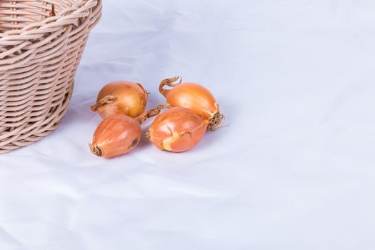 shallot in a wicker basket on a white background