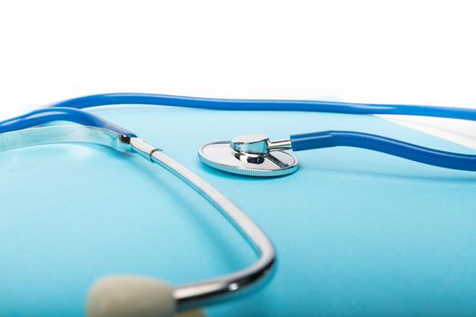 medical record and blue stethoscope close-up on white background in studio