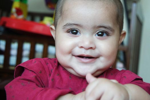Baby girl with lovely face, big eyes and cute face gesture. Toddler baby making sweet activities