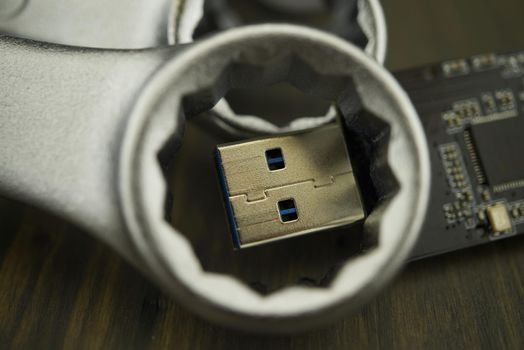 Set of spanners or wrenches in close up with jaws around a small electronic component and selective focus, technical support or smart tools concept