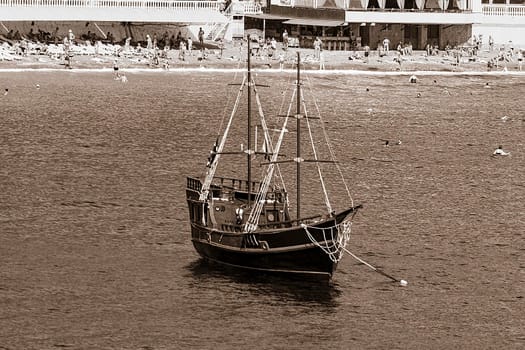 There's a beach in the background. Sepia color photo.
