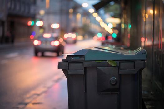 Urban street life with garbage container and street lights