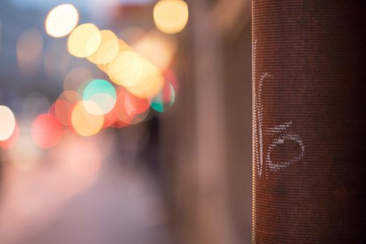 Closeup of rain drain, urban city lights in the blurry background