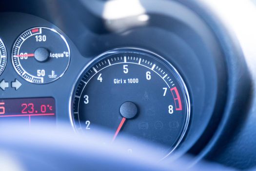 Closeup of the dashboard of a sports car, tachometer and fuel indicator