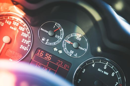 Closeup of the dashboard of a sports car, tachometer and fuel indicator