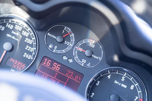Closeup of the dashboard of a sports car, tachometer and fuel indicator