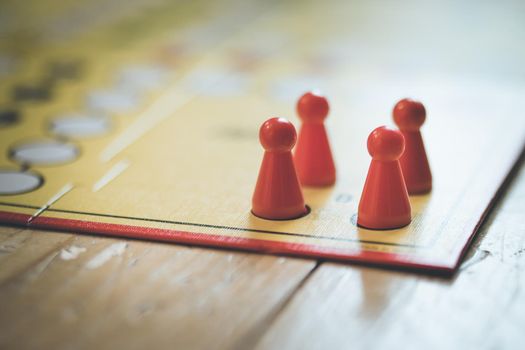 Meeples on a board, ready for playing a parlor game, ludo