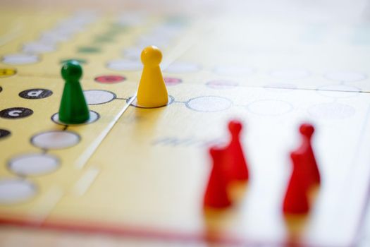 Meeples on a board, ready for playing a parlor game, ludo