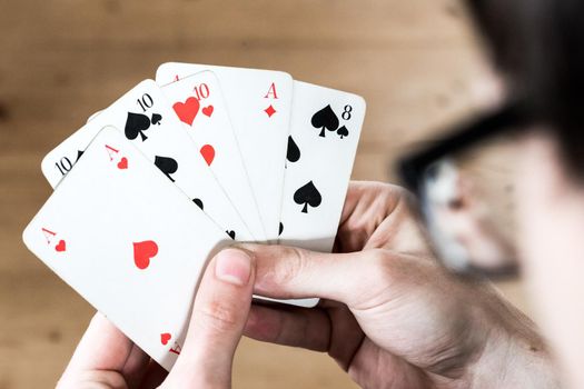 Man is playing cards, cutout of his hands