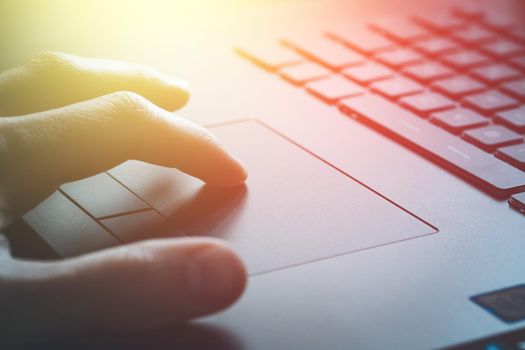 Close up picture of hands using a notebook touchpad, sunshine