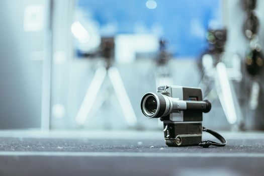 Vintage old movie camera, production studio in the blurry background