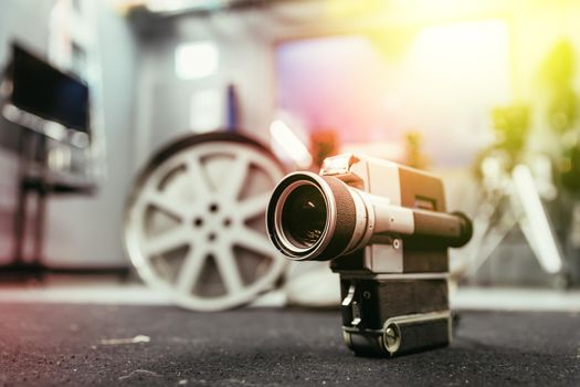 Vintage old movie camera, production studio in the blurry background