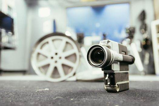 Vintage old movie camera, production studio in the blurry background