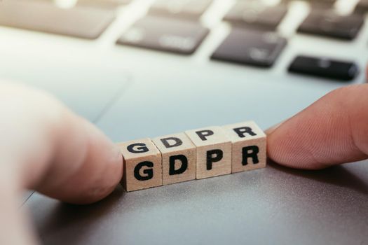 GDPR: Wooden cubes with letters “GDPR” lying on a laptop. General Data Protection Regulation