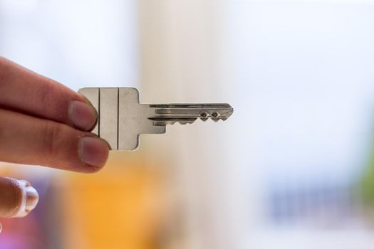 Holding a house key in the hand: New home and property.