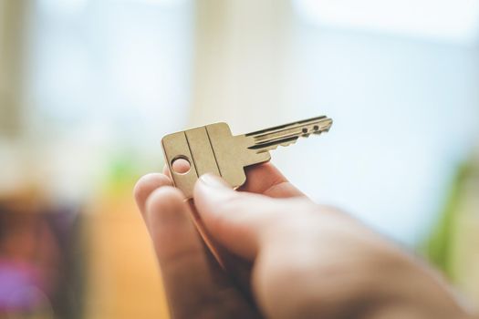 Holding a house key in the hand: New home and property.