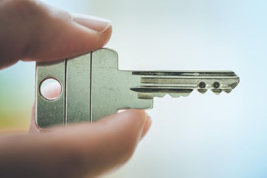 Holding a house key in the hand: New home and property.