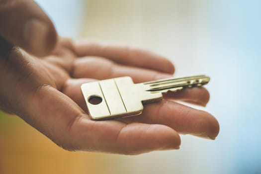 Holding a house key in the hand: New home and property.