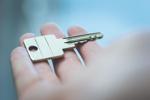 Holding a house key in the hand: New home and property.
