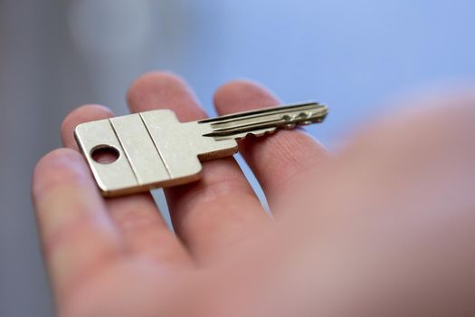 Holding a house key in the hand: New home and property.