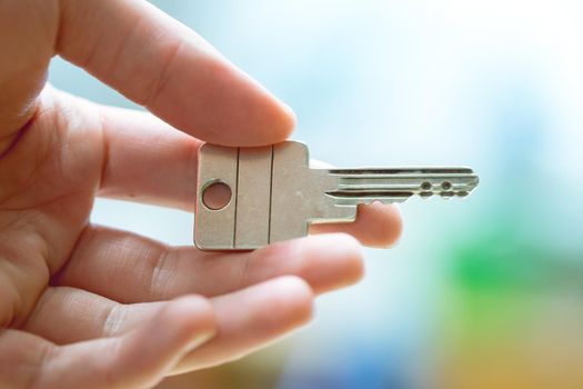 Holding a house key in the hand: New home and property.