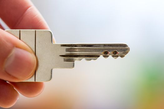 Holding a house key in the hand: New home and property.