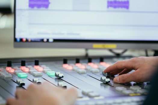Moderator and soundboard in radio broadcasting studio