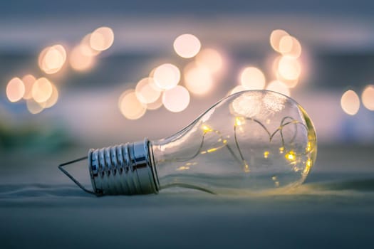 LED light bulb is lying in the bed. Symbol for ideas and innovation. Spot lights in the blurry background.