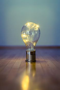 LED light bulb is lying on the wooden floor. Symbol for ideas and innovation. Copy space.