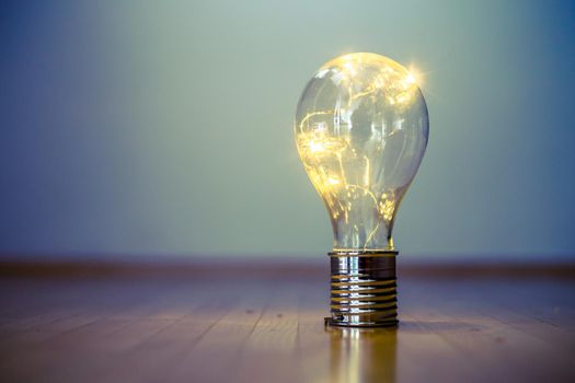 LED light bulb is lying on the wooden floor. Symbol for ideas and innovation. Copy space.