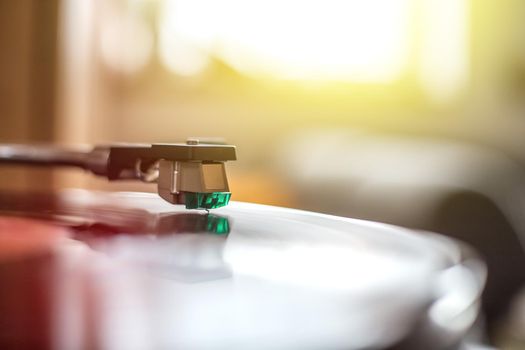 Close up picture of a record player, playing a record. Sunbeam.